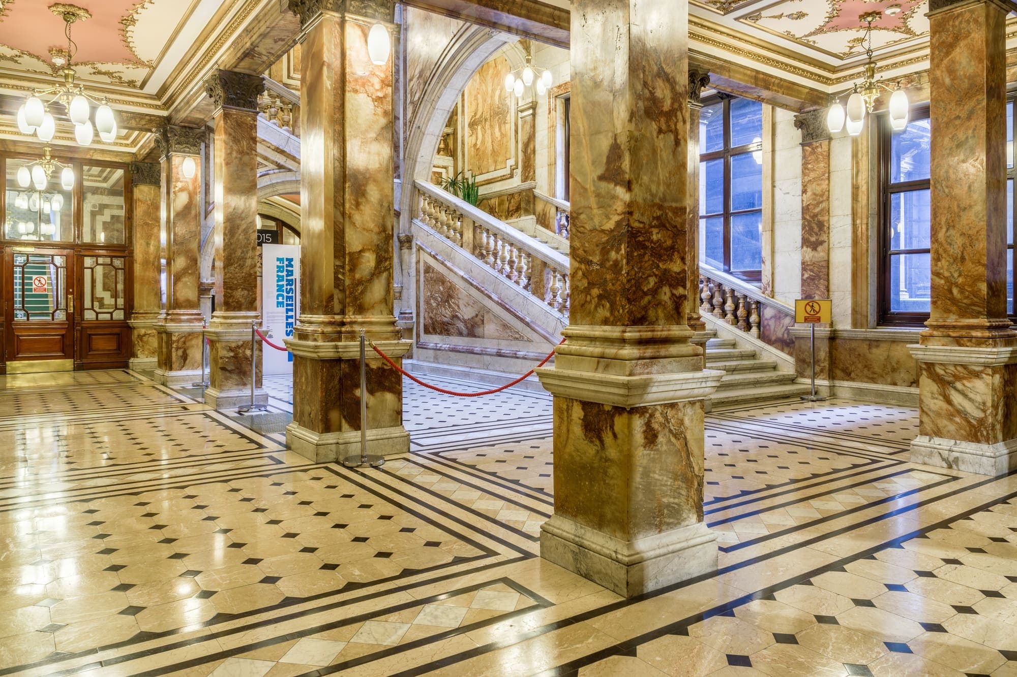Vestíbulo con piso de mármol pulido y columnas de piedra
